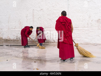 Les moines bouddhistes en robes rouges sont le nettoyage, monastère Rongwo Tongren County, Longwu, Chine Banque D'Images