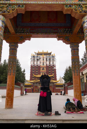 Pèlerins tibétains en priant et en se prosternant devant le monastère de Hankou Railway Station et à son tour de Milarépa, province de Gansu, Chine, Hankou Railway Station Banque D'Images