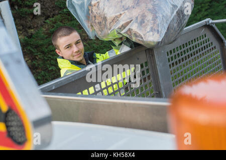 Les jeunes dustman transportant des sacs à Banque D'Images