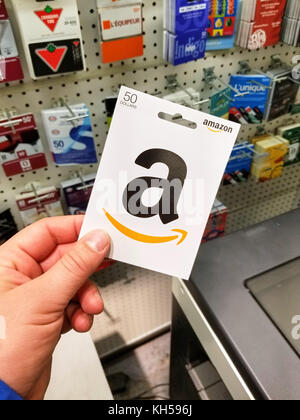 Montréal, Canada - le 7 novembre 2017 : 50 Carte cadeau amazon dollar dans une main sur les cartes-cadeaux Amazon. arrière-plan est un américain du commerce électronique et de clou Banque D'Images