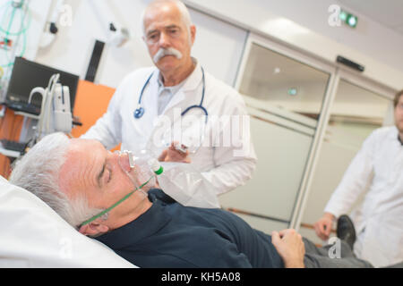 Médecin d'appliquer un masque à oxygène sur senior patient Banque D'Images