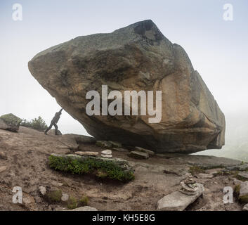 Homme avec une pierre énorme poussant dans les montagnes, la Russie. ergaki Banque D'Images
