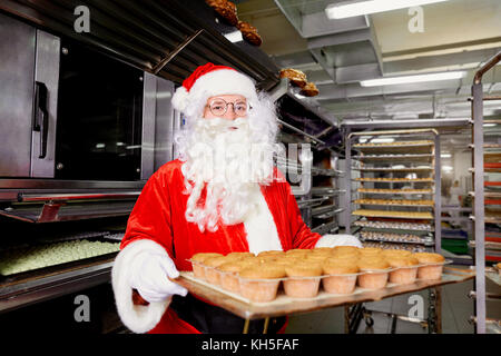 Santa Claus Baker avec un plateau de petits gâteaux dans ses mains sur le christ Banque D'Images