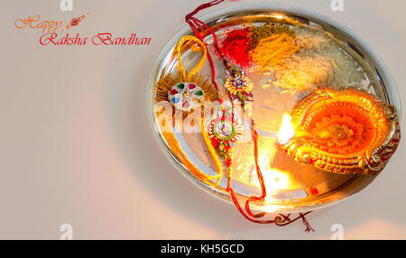 Raksha bandhan indian festival hindou le contenu de l'arrière-plan avec rakhi, lampe à huile en argile, du riz et des bonbons en poudre kumkum. Banque D'Images