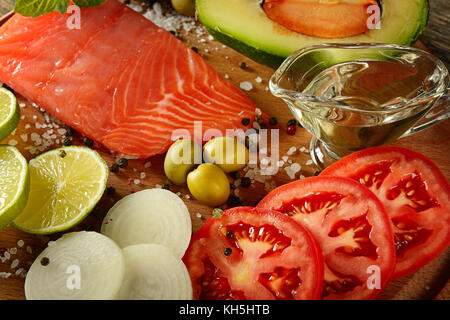 Le saumon rouge de viande, tomates, épices, des olives vertes et de l'huile d'olive sur table de cuisine. vue d'en haut. focus sélectif. Banque D'Images