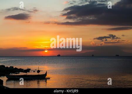 Coucher de soleil sur la baie de Manille. Sur la gauche, un héron est de regarder la scène paisible. Manille, Philippines Banque D'Images