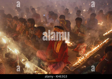 Dhaka, Bangladesh. 14 novembre 2017. Les dévots hindous bangladais s’assoient avec Prodip et prient Dieu au temple Shri Shri Loknath Brahmachari Ashram pour observer le festival sacré de Rakher Upobash ou Kartik Brati à Barodi, Narayanganj. Crédit : Md. Mehedi Hasan/ZUMA Wire/Alamy Live News Banque D'Images