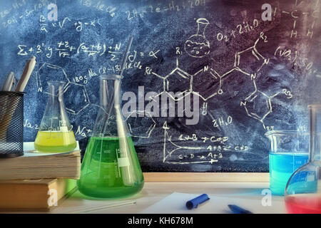 Classe 24 et tableau noir tiré de l'enseignement de la chimie avec des livres et d'instruments. L'enseignement des sciences chimiques concept. Composition horizontale. Bof Banque D'Images