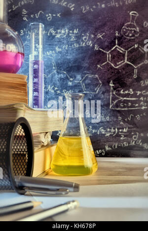 Classe 24 et tableau noir tiré de l'enseignement de la chimie avec des livres et d'instruments. L'enseignement des sciences chimiques concept. Composition verticale. Face Banque D'Images