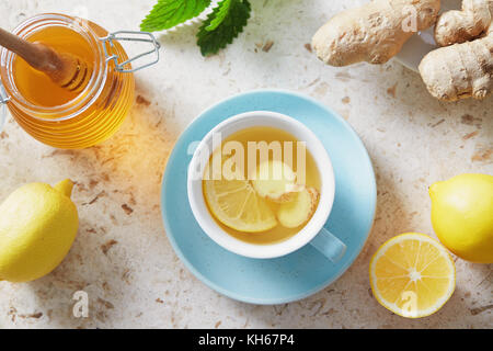 Thé au citron et au gingembre avec du miel. Tasse de thé chaud au miel et au citron avec racine de gingembre frais. Banque D'Images