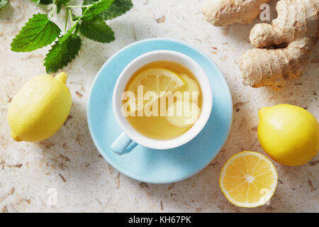 Thé au citron et au gingembre avec du miel. Tasse de thé chaud au miel et au citron avec racine de gingembre frais. Banque D'Images