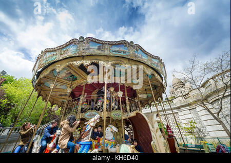 Les touristes prenant des photos tout en montant sur le carrousel traditionnel de Montmartre Banque D'Images