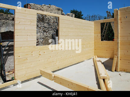 Porte avant et vide à l'intérieur d'un cadre wondow partiellement construits en bois (sapin) block house, une maison en bois qui est assemblé sur place. Certaines de t Banque D'Images