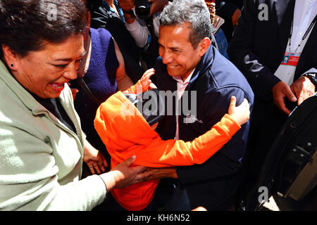 Un garçon dit adieu au président Ollanta Humala (centre) alors qu'il tente de quitter la Virgen de la Candelaria festival, Puno, Pérou Banque D'Images