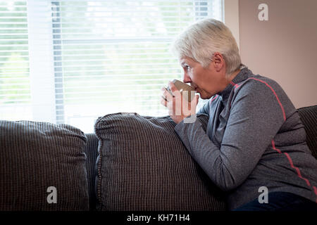 Senior woman drinking coffee at home Banque D'Images