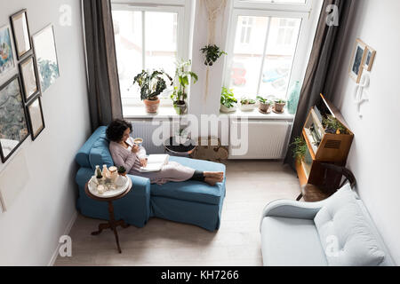 Belle femme tenant une tasse de café à la maison
