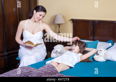 Sa fille mère, les adultes à lire, de toucher sa tête. studio shot Banque D'Images