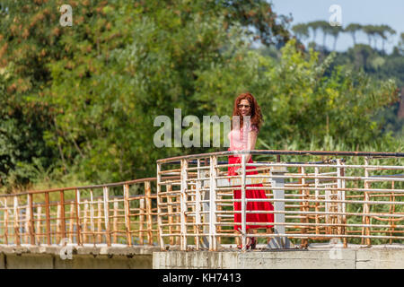 Red-haired girl irlandais marche sur un vieux pont en fer rouillé Banque D'Images