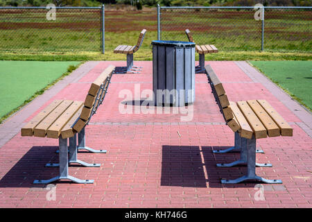 Un ensemble de 4 bancs sur une brique de ronde dans un parc. Banque D'Images