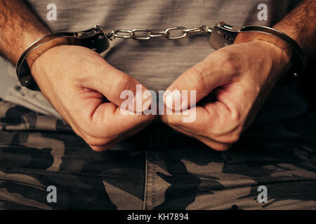 Soldat dans l'armée militaire menottes vêtements. prisonnier de guerre ou d'attentats terroristes arrêtés, près des mains dans les menottes, selective focus. Banque D'Images