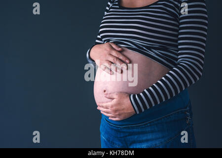 L'amour doux femelle enceinte avec les mains sur son ventre dans le troisième trimestre de la grossesse s'attendant bébé nouveau-né Banque D'Images