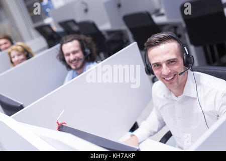 Young male téléphoniste du centre d'avoir fait son travail avec un casque Banque D'Images