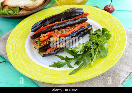 Les tranches d'aubergine au four farcies aux légumes. séjournant dans un plat végétalien. Banque D'Images