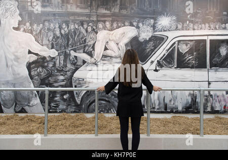 Saatch Gallery, Londres, Royaume-Uni. 15 novembre 2017. La Fondation de la famille Tsukanov et la Galerie Saatchi ouvrent Art Riot: Acitionnisme post-soviétique, une exposition consacrée à l'art de protestation post-soviétique au cours des 25 dernières années. L'exposition se déroule du 16 novembre 2017 au 31 décembre 2017. Photo: Un membre du personnel de la galerie voit le travail de l'exposition. Crédit : Malcolm Park/Alay Live News. Banque D'Images