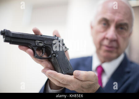 Le commissaire de police à la criminalité, David Jamieson, tenant une arme à feu au quartier général de la police des West Midlands police Lloyd House, Birmingham, après que Ray Wilkinson ait été invité à remettre une cache d'armes appartenant à son dernier oncle à la suite de la publicité entourant le lancement de la remise nationale d'armes à feu. Banque D'Images