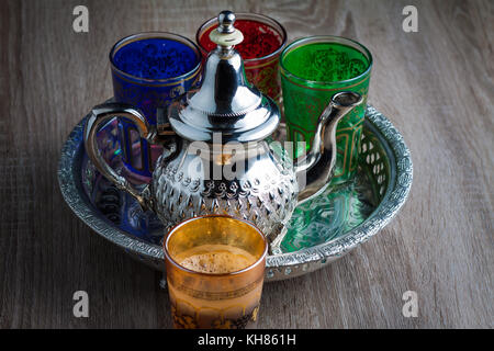 Close up d'un pot de thé marocain et verres sur une table en bois Banque D'Images