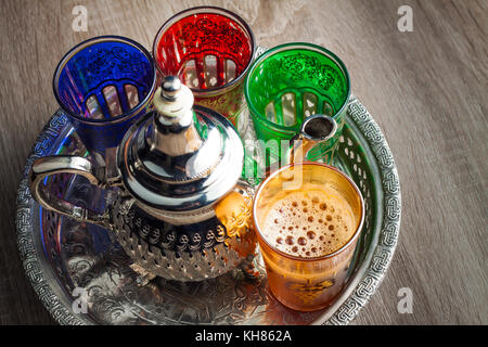 Close up d'un pot de thé marocain et verres sur une table en bois Banque D'Images