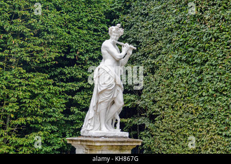 Jouant de la flûte statue dans le Dôme jardin du palais de Versailles, Versailles, France. Photo prise à l'été 2014. Banque D'Images