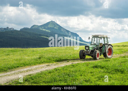 Vieux tracteur sur pré. Belle vue sur la montagne dans les alpes Banque D'Images