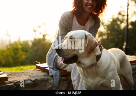 Cropped shot of young African lady wearing costume blanc avec de jolies balades dans la région de dog park Banque D'Images