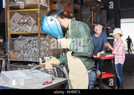 Les travailleurs de l'usine de métal et les soudeurs travaillent ensemble dans l'atelier Banque D'Images