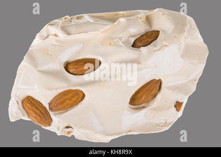 Nougat aux amandes miel turc. morceau de délicieux bonbon sucré isolé sur fond gris. Banque D'Images