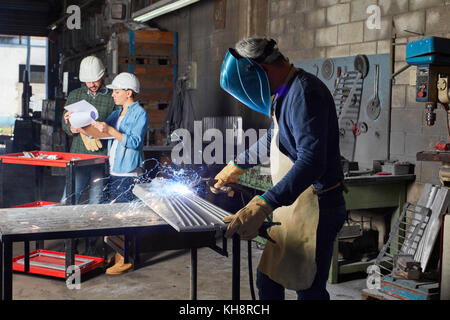 Atelier de soudure avec l'homme qui travaillent avec le métal avec une étincelle Banque D'Images