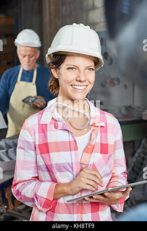 Jeune femme avec un ordinateur portable comme col bleu Banque D'Images