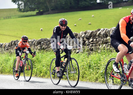 Les cyclistes à cheval sur un chemin de campagne dans le Yorkshire Dales, UK Banque D'Images