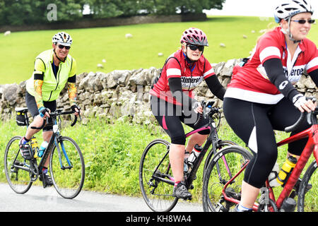 Les cyclistes à cheval sur un chemin de campagne dans le Yorkshire Dales, UK Banque D'Images