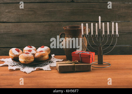 La menorah, des cadeaux et des beignets de hanouka Banque D'Images