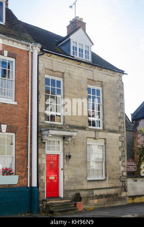 Maison de ville en pierre à puce dans High Street, Warwick, Warwickshire avec porte avant rouge vif Banque D'Images