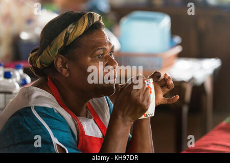 Joanna boire une tasse d'eau chaude. Joanna travaille à Port Vila, marché de fruits et légumes, Vanuatu. Banque D'Images
