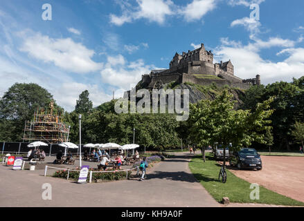 Les gens apprécient l'été météo à la terrasse d'un café dans l'ouest de Princes Street Gardens assombrie par Castle Rock avec le Château d'Édimbourg et le puits Ross Banque D'Images