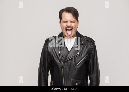 Crazy Man showing langue. man in black Jacket fermé les yeux et langue. studio shot Banque D'Images