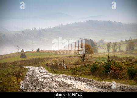 Boueux et route de campagne après la pluie dans les montagnes des Carpates. chemin Chemin de terre rurale extrême dans les collines. le mauvais temps Banque D'Images