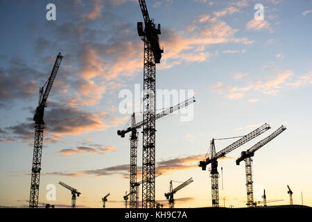 Silhouettes de grues de construction dans la soirée sur un chantier de Friedrichshain, Berlin 2017 Banque D'Images