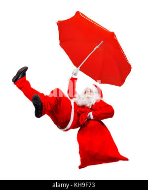 Drôle de père noël volant tombe avec un sac rempli de cadeaux. x-mas santa chute détient comme parapluie parachute. père noël passez avec parasol et transporter sac Banque D'Images