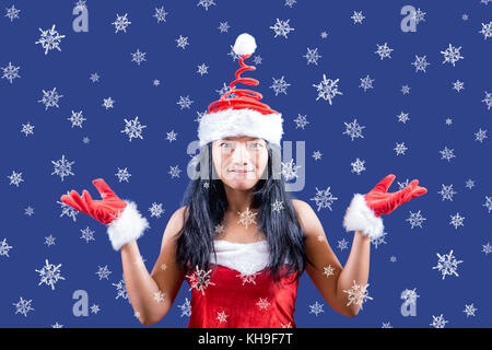 Mme. Noël ressemble à l'appareil photo avec ses mains montre des flocons. grand flocons de neige tombent autour de mrs claus. Banque D'Images