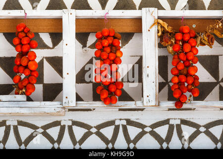 Le séchage des tomates sur un mur à la décoration traditionnelle d'une maison de village Pyrgi sur l'île de Chios, Grèce. Banque D'Images